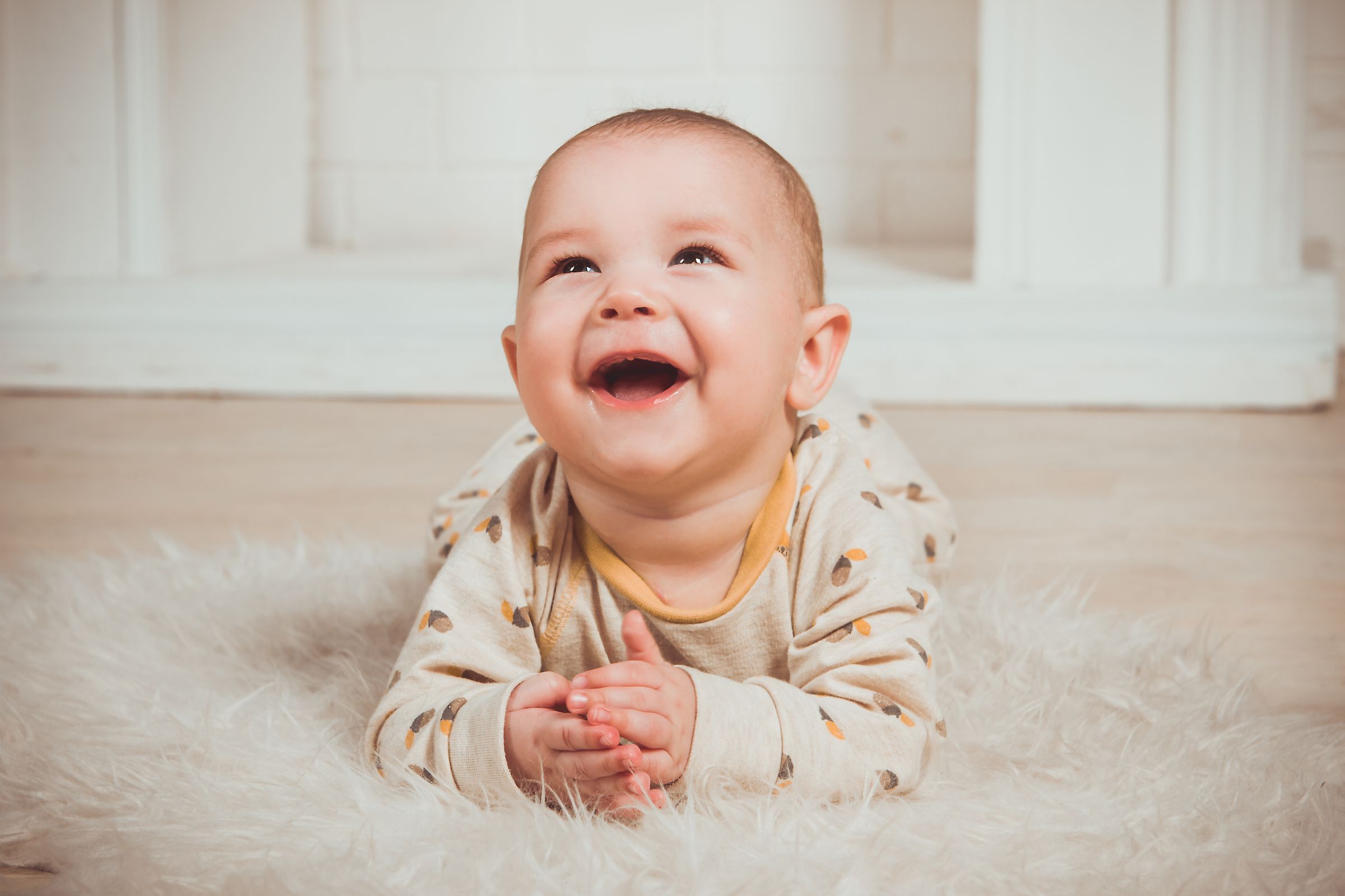 A joyful baby on tummy time, smiling, in the infant programme at Moonlite Montessori
